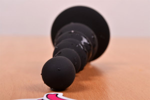 Anální kolík Black Cascade s přísavkou, na stole