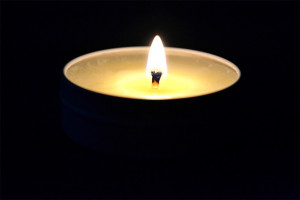 Masážní svíčka Paris Romance – ukázka hořící svíčky ve tmě