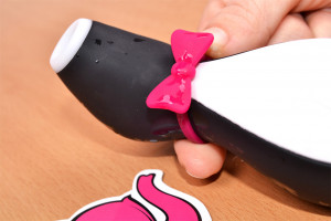 Satisfyer For Penguin – egy rózsaszín masni részlete egy kütyüben